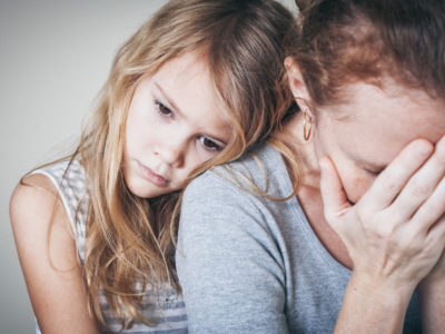 sad daughter hugging her stressed mother